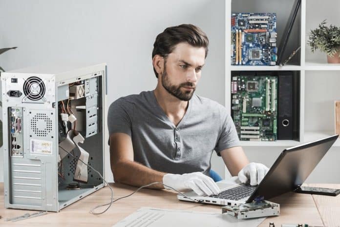 Un homme qui répare un ordinateur