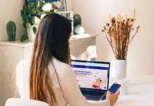 a woman sitting at a table using a laptop computer