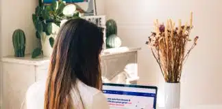 a woman sitting at a table using a laptop computer