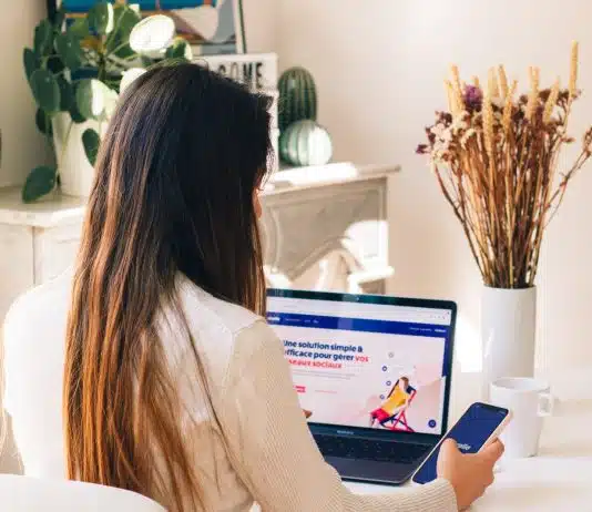a woman sitting at a table using a laptop computer